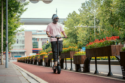 KuKirin G2 electric scooter riding through a modern city street